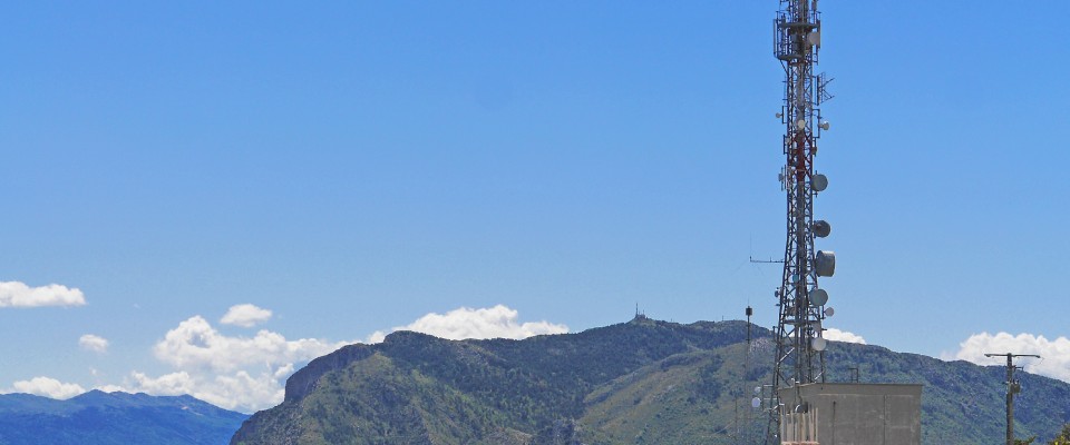Foto de antena eléctrica de comunicaciones frente a una montaña