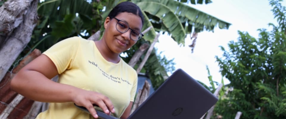 foto de una mujer sonriendo sosteniendo un computador foto de una mujer sonriendo sosteniendo un computador