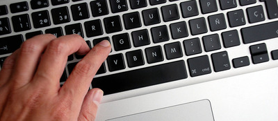 Foto de una mano sobre el teclado de un computador