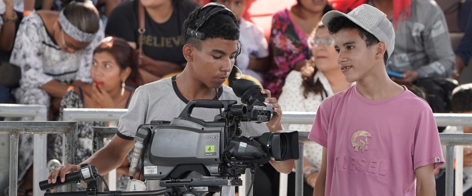 Foto de dos adolescentes junto a una cámara cinematográfica