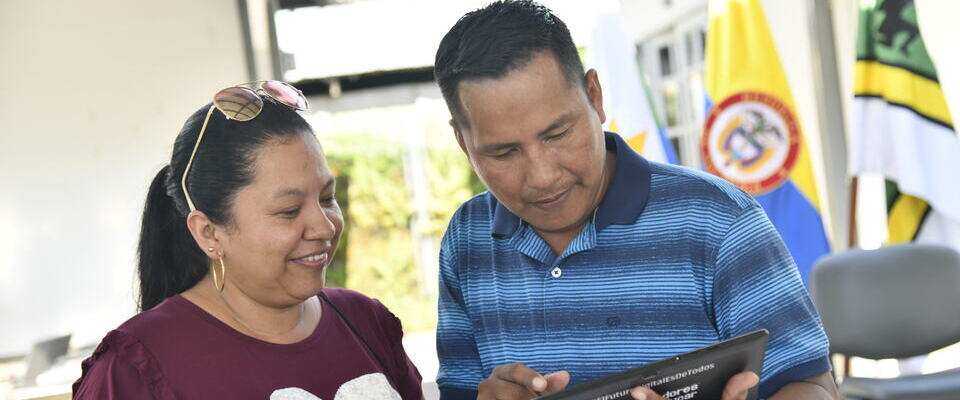 Foto de una ciudadana y un ciudadano observando una tablet