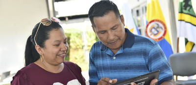Foto de una ciudadana y un ciudadano observando una tablet