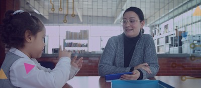 Foto de una maestra junto a su estudiante
