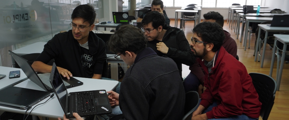 Foto de un grupo de hombres observando un computador
