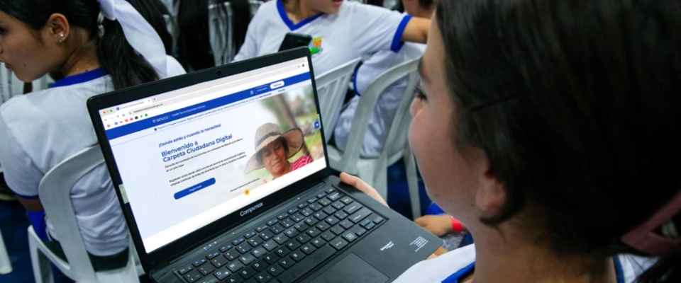 Foto de una estudiante observando un computador portatil