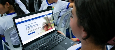 Foto de una estudiante observando un computador portatil