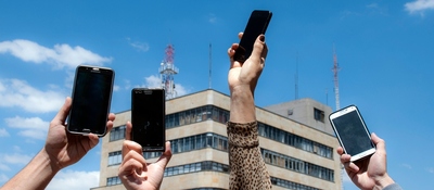 Foto de 4 manos sosteniendo dispositivos moviles