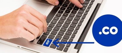Imagen diseñada de una mano sobre un teclado resaltando la tecla .co Imagen diseñada de una mano sobre un teclado resaltando la tecla .co
