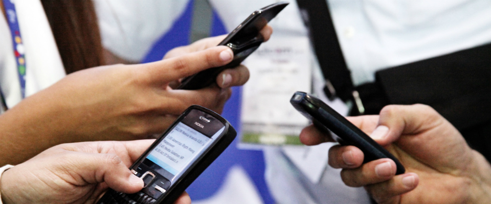 Foto de varias manos sosteniendo teléfonos móviles