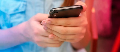 Foto de las manos de un niño sosteniendo un celular