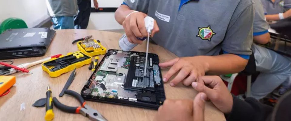 Foto de un jóvenes en una clase tecnica de reparación de equipos