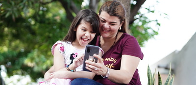 Foto de madre e hija consultando un móvil