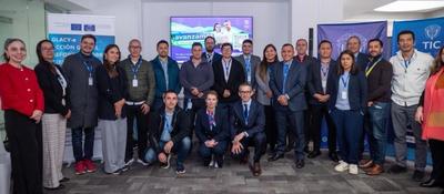 Funcionarios y profesionales posan en evento institucional con banners de MinTIC y cooperación internacional sobre ciberseguridad