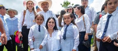 Ministra TIC y estudiantes posan al aire libre en un acto público, con autoridades y comunidad reunidas en entorno rural.