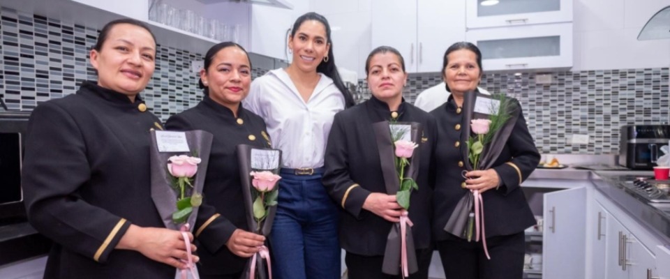 Ministra TIC y colaboradores con uniforme sostienen rosas rosadas, en un gesto de reconocimiento y celebración.