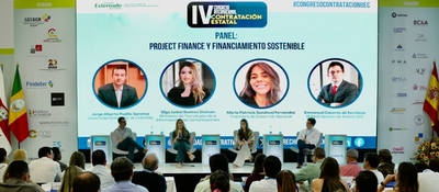 Panel de expertos en escenario con pantalla grande; público atento escucha debate sobre contratación pública y tecnología del Ministerio TIC.