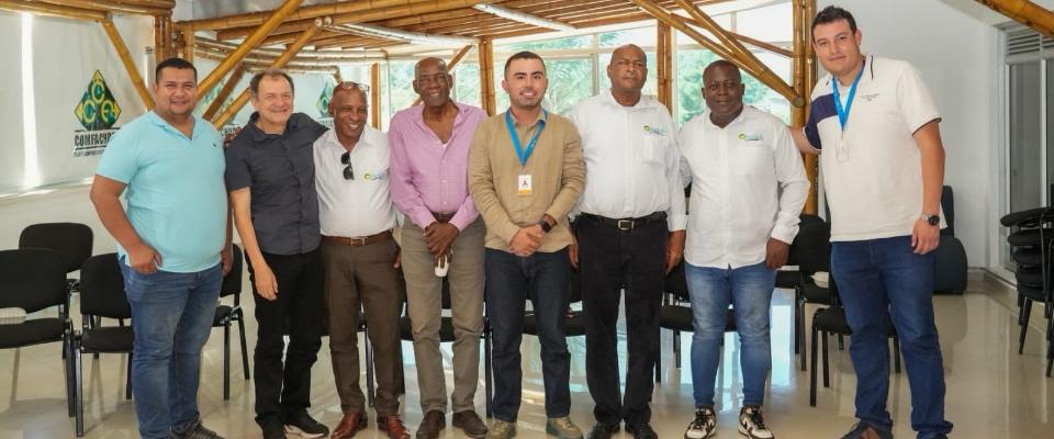 Ocho hombres posan en salón con estructura de madera. Representan MinTIC y Comité Cívico del Chocó tras acordar ruta de conectividad.