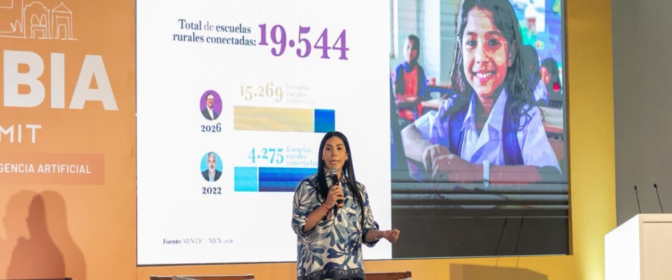 Foto de la Ministra TIC en presnetación durante el evento, al fondo una pantalla con la imagen de una niña
