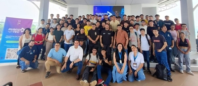 Estudiantes y formadores reunidos en sede educativa posan para foto grupal junto a aviso de AvanzaTEC, símbolo de capacitación tecnológica
