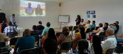 Personas sentadas en aula observan proyección; capacitación sobre implementación de Política de Gobierno Digital en entidades de la Amazonía.