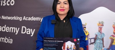 Mujer con blazer azul sostiene reconocimiento de Cisco en Academy Day Colombia 2026, destacando formación de talento con AvanzaTEC.