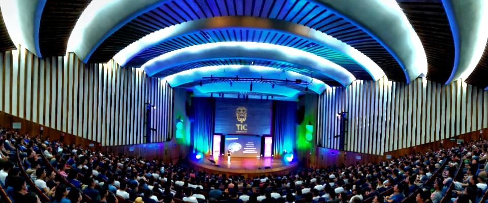 Auditorio lleno durante Colombia 5.0 en Santander, con escenario iluminado y público atento a charlas sobre innovación y sector TI.