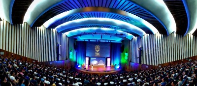Auditorio lleno durante Colombia 5.0 en Santander, con escenario iluminado y público atento a charlas sobre innovación y sector TI.
