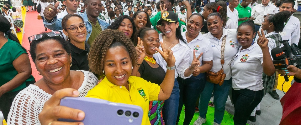 Grupo de mujeres y asistentes sonríen y se toman una selfie en evento multitudinario, reflejando inclusión y avance en conectividad rural