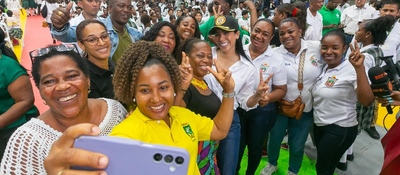 Grupo de mujeres y asistentes sonríen y se toman una selfie en evento multitudinario, reflejando inclusión y avance en conectividad rural