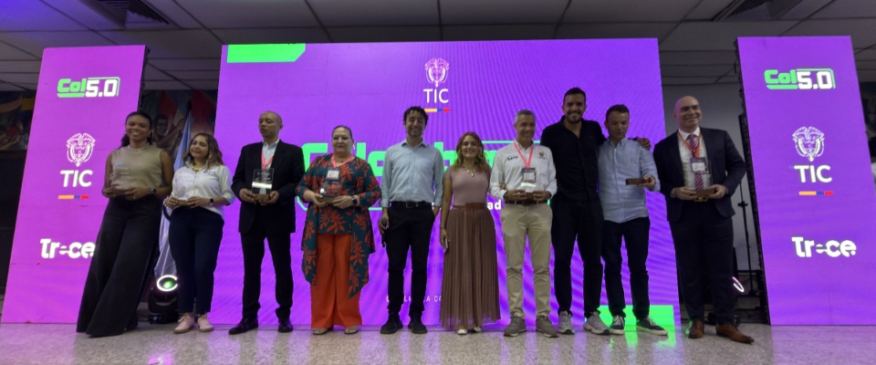 En la foto se ven expositores en el escenario con un fondo referente a Col50