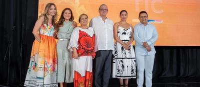 Seis personas posan en escenario frente a pantalla naranja; evento celebra 40 años de Telecaribe como referente cultural del Caribe.