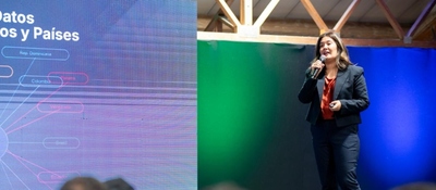 Mujer expone sobre Latam GPT y datos regionales en escenario tecnológico enfocado en inteligencia artificial latinoamericana.