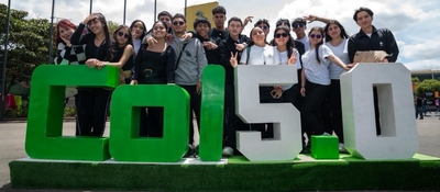 Grupo de jóvenes posa junto al letrero Colombia 5.0 durante evento tecnológico que reunió miles de visitantes.