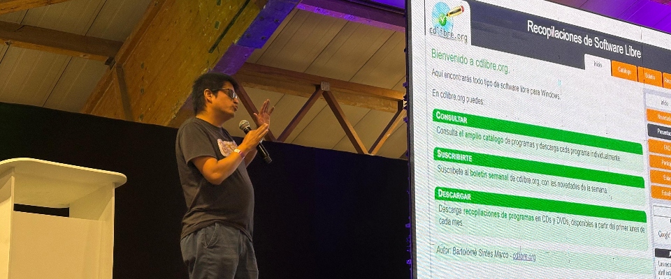 Foto de presentador en escenario exponiendo sobre Software Libre