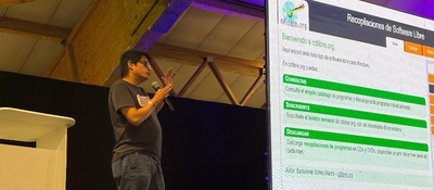 Foto de presentador en escenario exponiendo sobre Software Libre