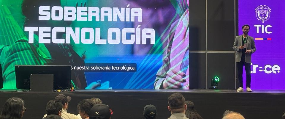 Foto de charla sobre videojuegos, escenario con una presentación de fondo