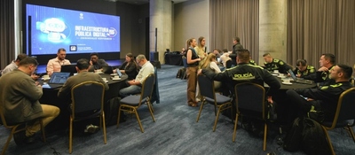 Funcionarios y policías participan en mesas de trabajo sobre Infraestructura Pública Digital en un salón de conferencias