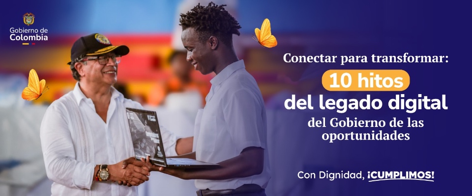 Estatua frente a edificios públicos y bandera de Colombia ondeando bajo cielo azul, símbolo de transformación digital.