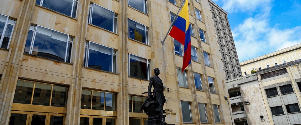 Foto del edificio del Ministerio TIC, la estatua de Murillo Toro y la bandera ondeante de Colombia