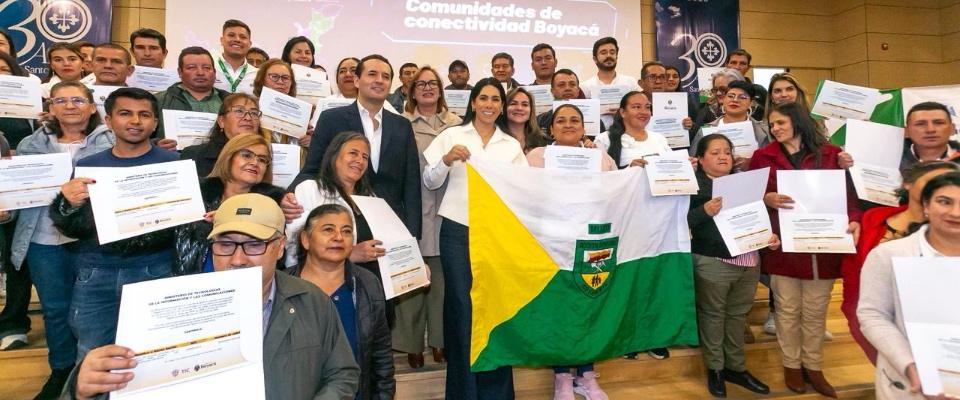 Grupo de ciudadanos en Boyacá muestra certificados y bandera regional durante entrega de apoyos de conectividad del MinTIC