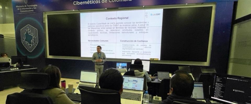 Funcionarios observan presentación técnica en centro de monitoreo digital durante preparación de conectividad electoral 2026