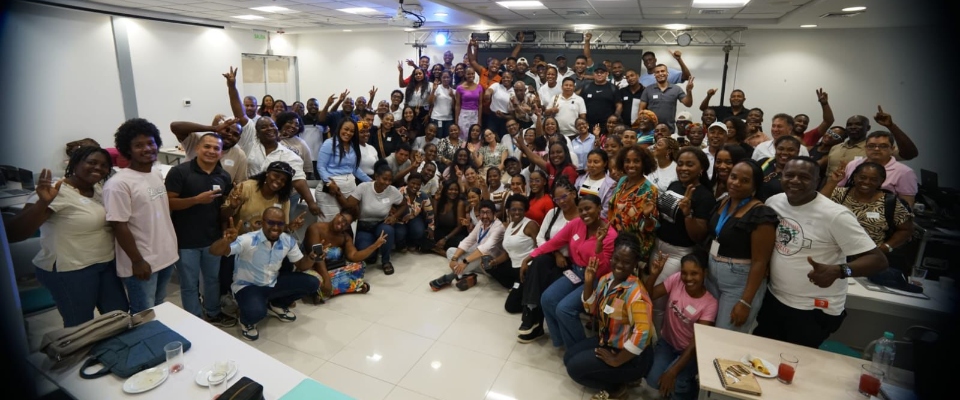 Decenas de líderes y participantes posan en salón de eventos durante encuentro TIC para impulsar la transformación digital.
