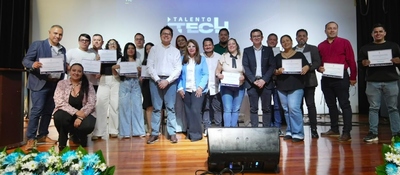 Grupo de graduados y directivos posa en escenario con certificados durante el cierre de Talento Tech en Risaralda.