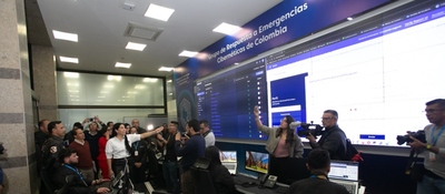 Funcionarios y periodistas observan un centro de monitoreo cibernético durante la coordinación de acciones electorales.