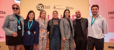 Siete personas posan frente al panel de un evento audiovisual tras el anuncio de las películas nominadas a los Premios Macondo