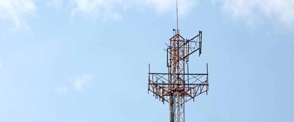 Parte superior de una torre metálica con antenas sobre cielo azul con nubes blancas dispersas. Parte superior de una torre metálica con antenas sobre cielo azul con nubes blancas dispersas.