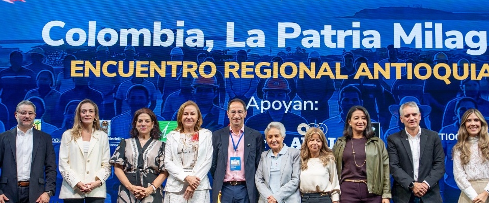 Diez personas posan en fila frente a un fondo azul con el texto «Encuentro Regional Antioquia». Diez personas posan en fila frente a un fondo azul con el texto «Encuentro Regional Antioquia».